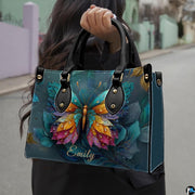 Angled view of matching butterfly handbag set showcasing intricate feathered wing artwork