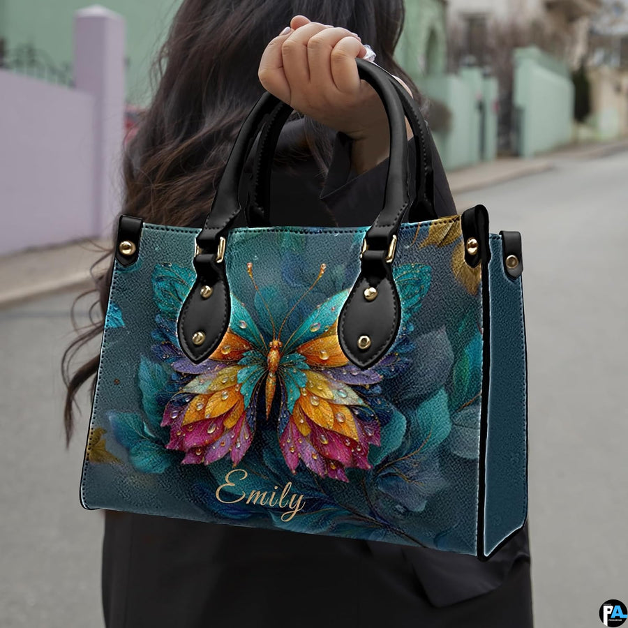 Angled view of matching butterfly handbag set showcasing intricate feathered wing artwork