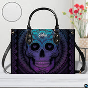 Sugar skull handbag on white table beside floral bouquet with texture swatch inset.