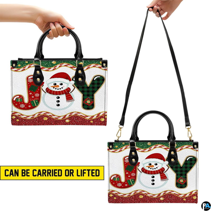Front view showing dual top handles, attachable shoulder strap, and seasonal snowman illustration.