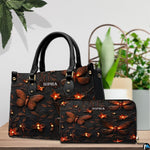 Glowing firefly handbag and matching wallet displayed together on a wooden tabletop near houseplants.