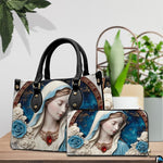 Tabletop lifestyle display showing porcelain Madonna handbag and matching wallet beside potted house plants.
