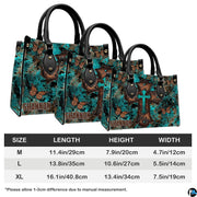 Angled perspective view of turquoise cross butterfly handbag highlighting rustic patina artwork.