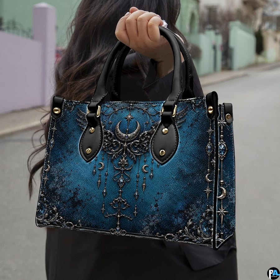 Gothic raven skull handbag carried outdoors by top handle on residential street.