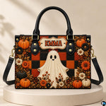 Studio display of the ghost plaid satchel resting upright on a circular neutral pedestal.