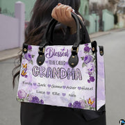 Front view of floral handbag featuring clustered purple roses and fluttering yellow butterflies.