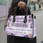 Front view of floral handbag featuring clustered purple roses and fluttering yellow butterflies.