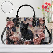 Close-up front view of matching zippered wallet showing black kitten portrait