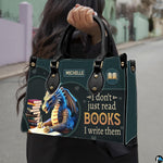Author blue dragon handbag carried outdoors by top handle along residential street.