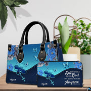 Handheld item and companion accessory with blue peony and rosary art placed together on wooden table near potted plant.