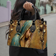 Matching wallet displaying sculpted Virgin Mary bas-relief artwork with praying hands and golden flowers