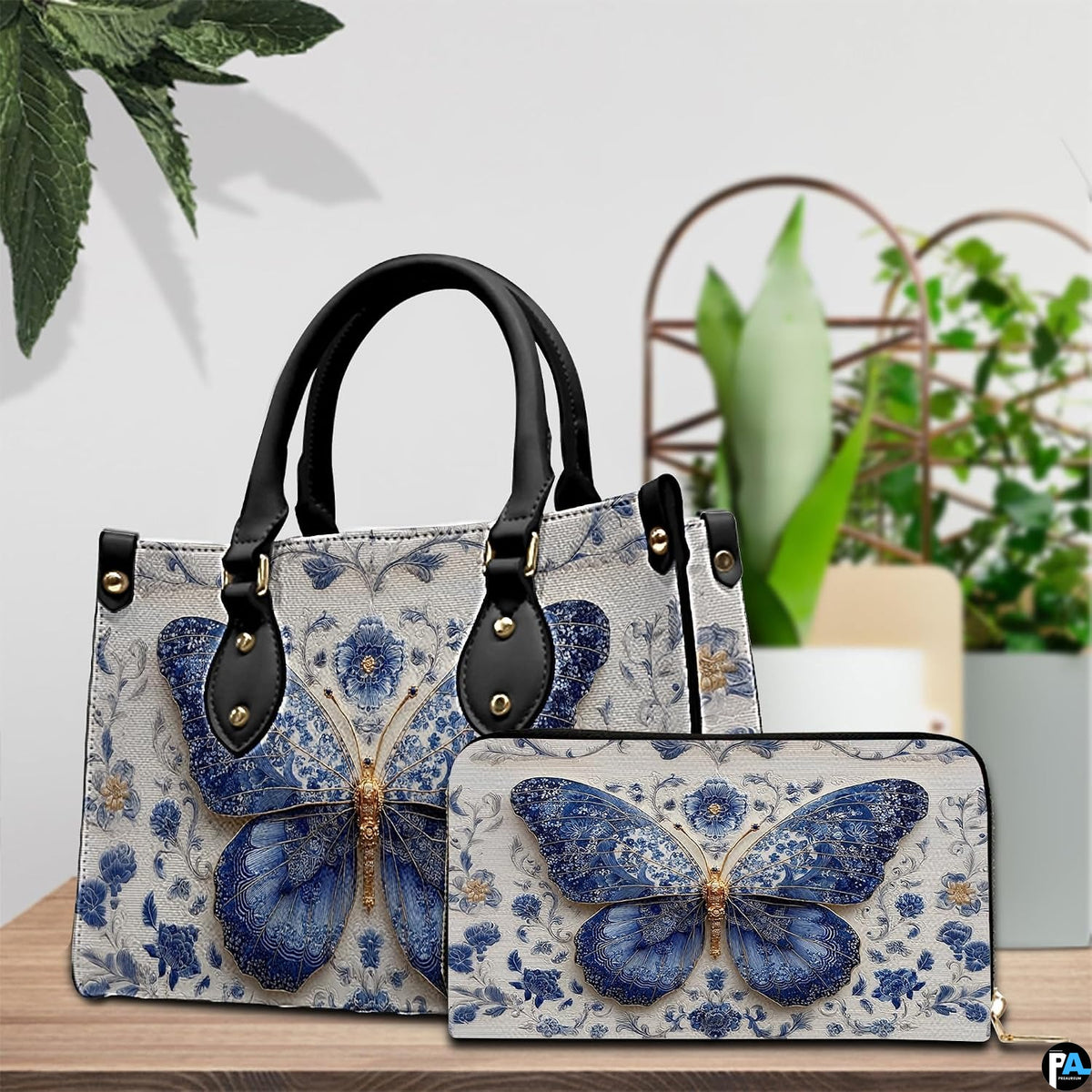 Tabletop display showing Delftware butterfly handbag and matching wallet beside indoor plants