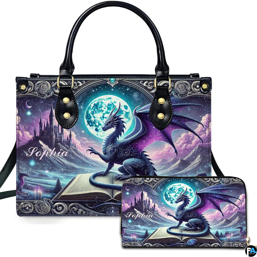 Studio front view of handbag and matching wallet with winged dragon on spellbook against full moon artwork.