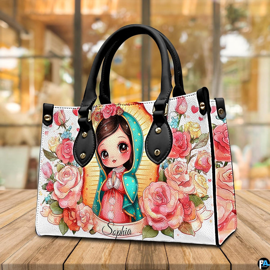 Chibi Virgin Mary handbag displayed on a wooden tabletop in front of a sunlit window.