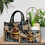 Coordinated arrangement of handbag and wallet showing the matching jeweled bee design.