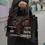 Front view of gothic cross handbag showing blooming red roses and thorny vines on dark background.