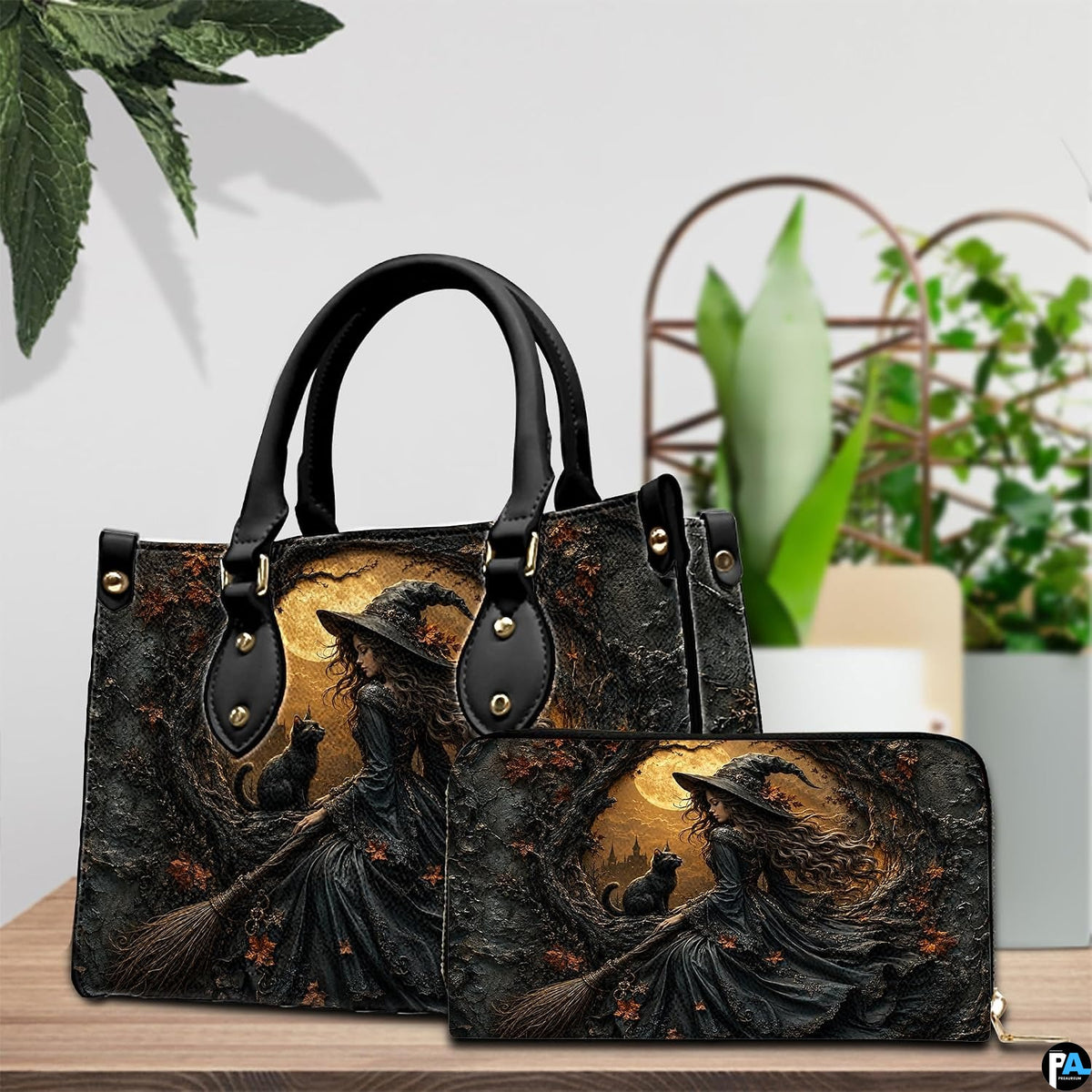 Indoor tabletop presentation featuring both witch and black cat art accessory items beside potted greenery.