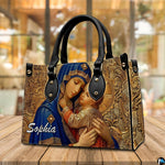 Virgin Mary in royal blue robe handbag presented on natural wooden tabletop