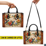 Handbag displayed held by top handle and detachable shoulder strap demonstrating carrying styles.