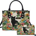 Front view of black cat wildflower garden handbag and matching wallet set with botanical flowers