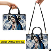 Dual carry style demonstration showing blue tile praying Madonna handbag.